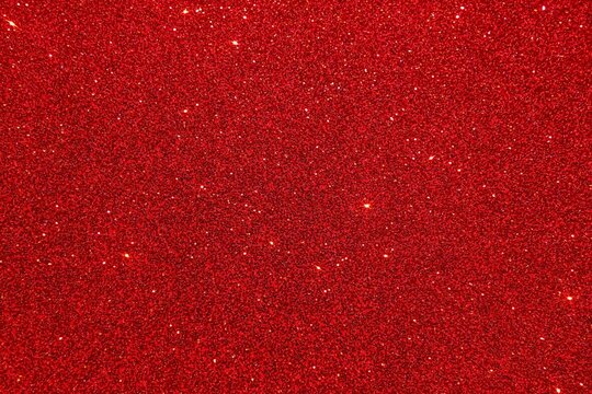 A vibrant red glitter background with sparkling light reflecting off surface