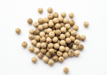 Pile of white peppercorns scattered on a white background in a close up studio shot view from above
