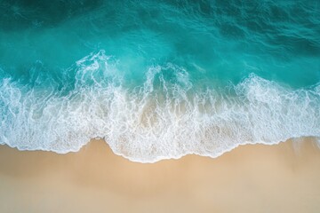 Turquoise ocean waves crashing onto sandy shore under bright sunlight, Aerial shot of turquoise ocean waves crashing onto sandy shore