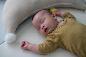 Baby sleeping peacefully on soft mat at home
