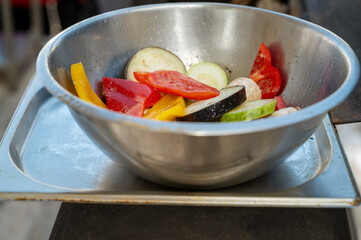 Mix of fresh vegetables in a stainless steel bowl on scales