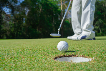 Golfer playing golf in the evening golf course, on sun set evening time.