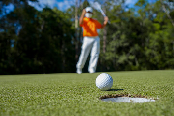 Golfer playing golf in the evening golf course, on sun set evening time.