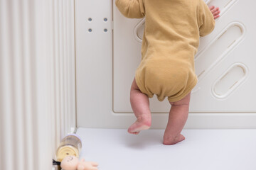 Baby learning to stand in playpen alone