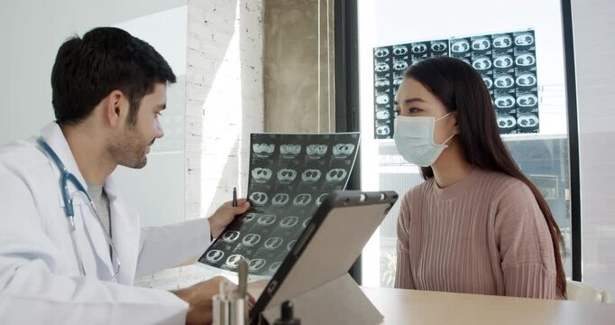 Doctor standing with laptop examine x-ray flim for patient in the hospital.