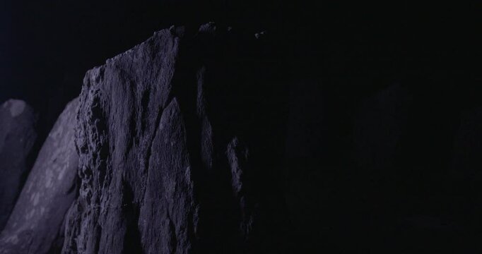 A jagged ancient stone stands in shadow at Drombeg Circle, catching faint light and evoking silence, ritual, and the unknown.