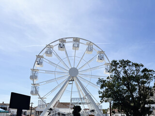 Ferris wheel and parked cars in sunny Nazare, Portugal urban scenery