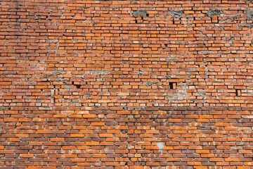 Naklejka premium Red brick wall with rough aged surface details