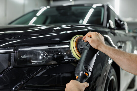 Car detailing and polishing process. Expert polishing car front lights in auto repair shop.