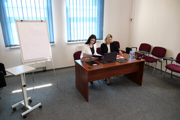 Two women meet to discuss a project and sign a contract.
