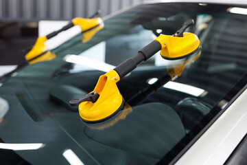 Suction pads for car windshield installing in workshop.