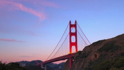 Fototapeta premium Majestic Golden Gate Bridge at sunset with beautiful pink and purple sky showcasing its iconic red towers and cables.