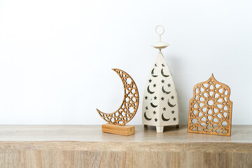 Lantern, Crescent Moon With Muslim Ornament Stand On Wooden Table Over White Background
