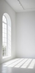 Fototapeta premium A bright, empty white room features a large arched window, allowing warm sunlight to stream in, casting soft shadows on the smooth floor.