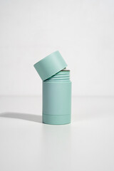 turquoise cylinder skincare product with the cap slightly open on white background