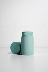 turquoise cylinder skincare product with the lid open on white background