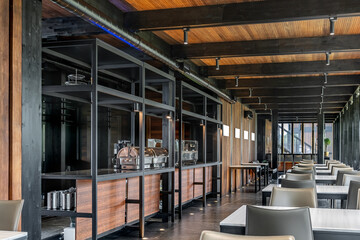 cozy restaurant, rustic atmosphere. wooden walls and ceiling. There are many tables and chairs in...