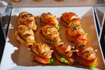 Freshly made croissant sandwiches with lettuce and tomato on display