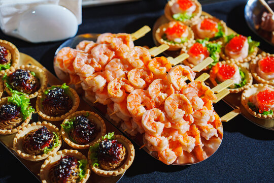 Shrimp skewers and gourmet appetizers displayed at a festive event