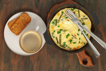 Healthy breakfast - frittata with vegetables and coffee with cookies on the table. Top view