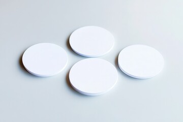 Four blank circular coasters arranged on a light surface, ideal for branding or product display