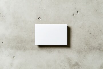 Minimalist blank business card on a textured concrete surface, ideal for branding mockups