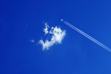 one single small fluffy white cloud in blue sky
