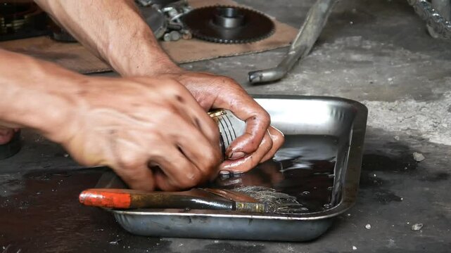 A motorcycle mechanic performs repairs and maintenance, cleaning on motorcycle pistons