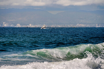 Wave forms giving a dramatic luster to the water with a boat in the background sitting on the...