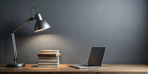 Fototapeta premium Minimalist desk with a single desk lamp on a dark simple gray background, featuring a stack of books and a laptop computer, minimalist desk, dark gray background