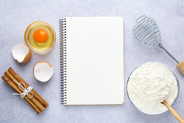 Blank recipe book, whisk and products on light table, top view. Mockup for design