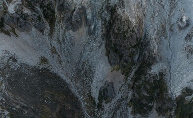 High-angle view of rugged mountain terrain, showing rocky slopes, valleys, and streams