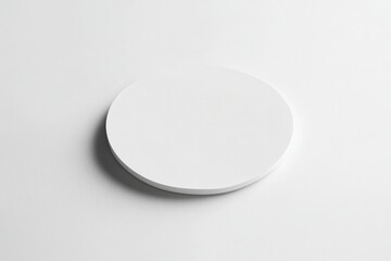 Minimalistic white circular object on a clean surface, ideal for product display or branding
