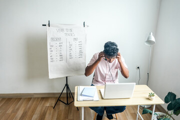 Young teacher man wearing headset, use online video conferencing systems to teach students.
