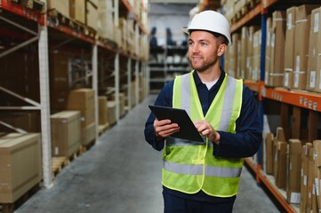Portrait of warehouseman with clipboard checking delivery, stock in warehouse