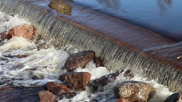 small dam with water flowing over
