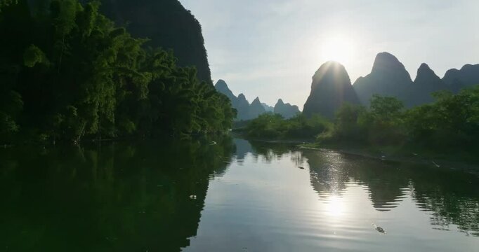 Aerial view low over the Lijiang river, calm, summer day in Yangshuo, China