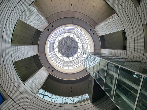 Looking up at the mesmerizing geometric design of a modern architectural marvel in an urban setting during daylight