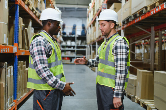 Two warehouse workers shaking hand when success project or first time greeting in a distribution center warehouse
