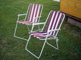 Old striped folding chairs in a rural garden