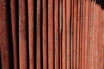 Old wooden red fence with peeling paint