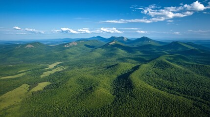 Obraz premium From above, you can see mountains covered in dark green forests under a sunny blue sky. This is a view of the Carpathian Mountains in Ukraine. A great place for adventure! 