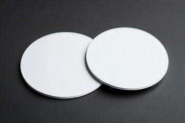 Two blank round coasters on a dark surface, ideal for product photography and branding