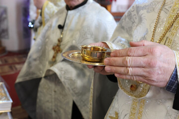 During the liturgy, the priest holds a cup of wine in his hand.