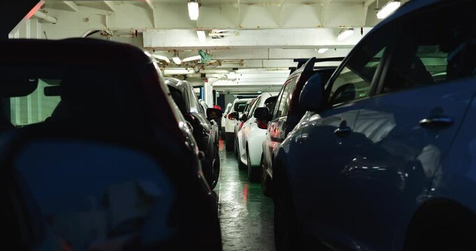 Modern vehicles stand parked on floor of cargo compartment of ferry during sea travel. Vessel serves as means of transport to provide water crossing