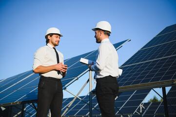 Businessman and worker near solar energy batteries