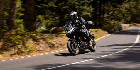 Wide Shot of a Motorcycle Rider in freeze Motion. Motion Blur Effect. Action Sports Shot of Touring Motorbike.