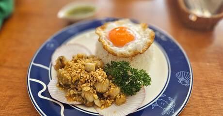 Stir-fried Scallops with garlic with streamed rice serving on blue plate