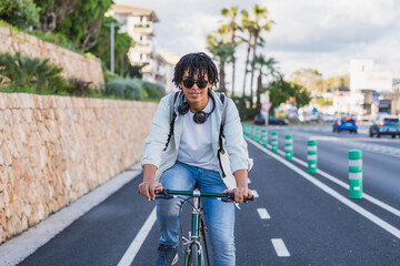 Young African American Man Cycling on Protected Bike Lane - Confident young man rides a bicycle on...