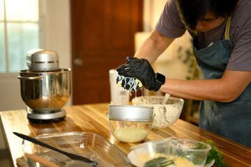 Close up of hands in gloves pressing butter to separate out liquid buttermilk
